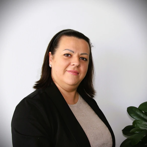 Bild einer weiblichen Zeitarbeitskraft. Dunkle Haare. Heller Hintergrund.